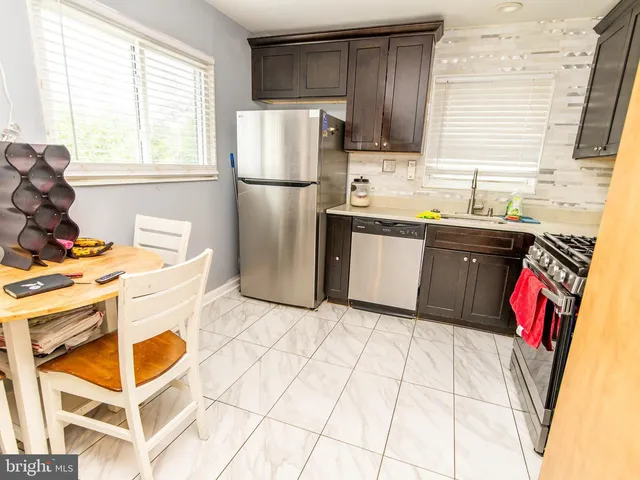 a kitchen with granite countertop a refrigerator and a stove top oven