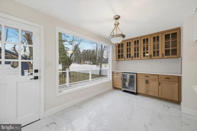 a living room with stainless steel appliances granite countertop a stove and a large window