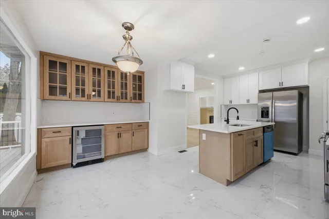a kitchen that has a lot of white cabinets and stainless steel appliances