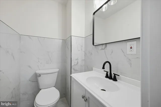 a bathroom with a sink mirror and toilet