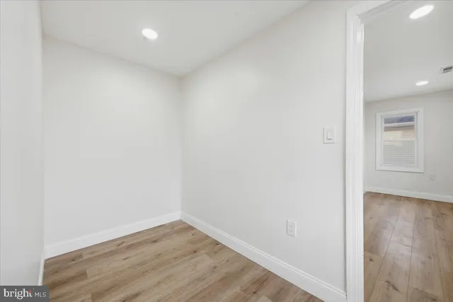 a view of a small space with wooden floor and a window