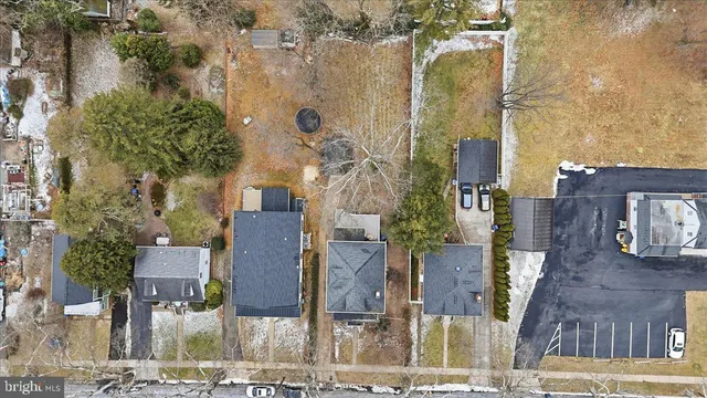 an aerial view of residential houses with outdoor space and parking