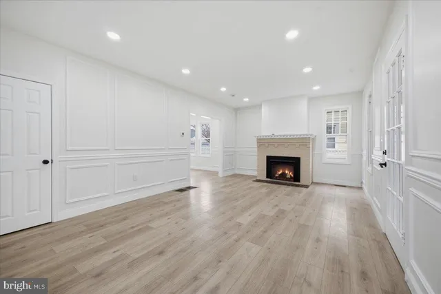 a view of a livingroom with wooden floor and a fireplace