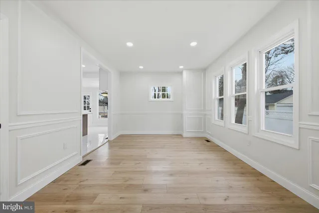 a view of empty room with wooden floor and windows