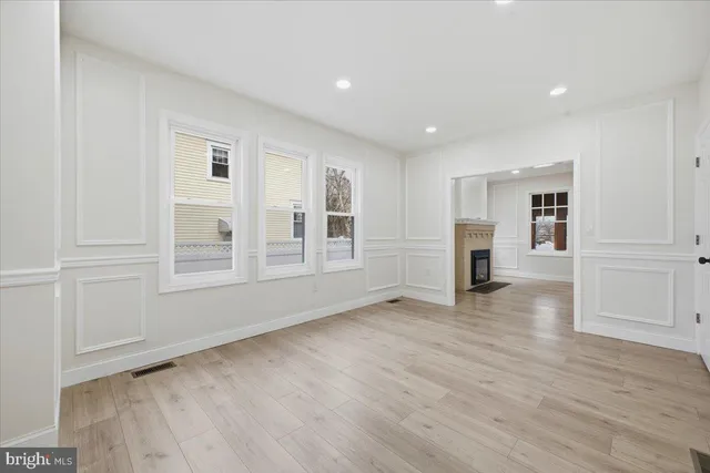 a view of empty room with wooden floor and cabinet