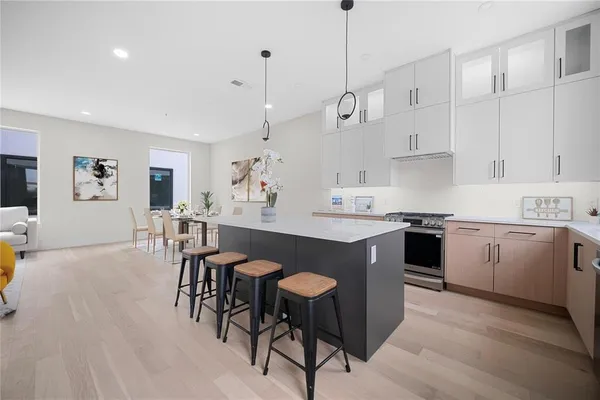 a kitchen with kitchen island granite countertop a sink a counter space and stainless steel appliances