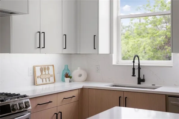 a kitchen with stainless steel appliances a sink a stove and a window