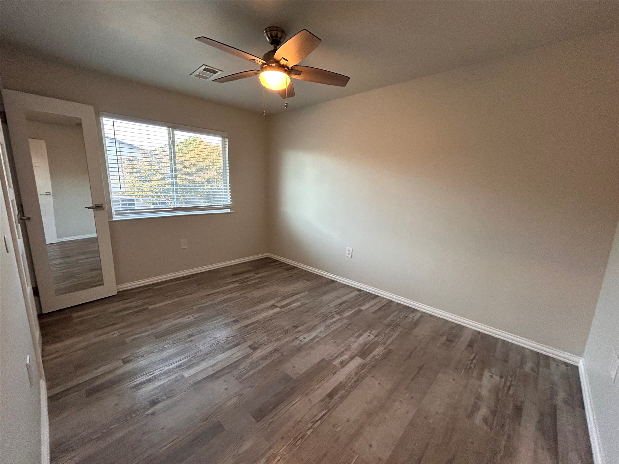 8920 Trone Circle, Unit B Austin, TX 78758 - Photo 15 of 19 an empty room with wooden floor and windows