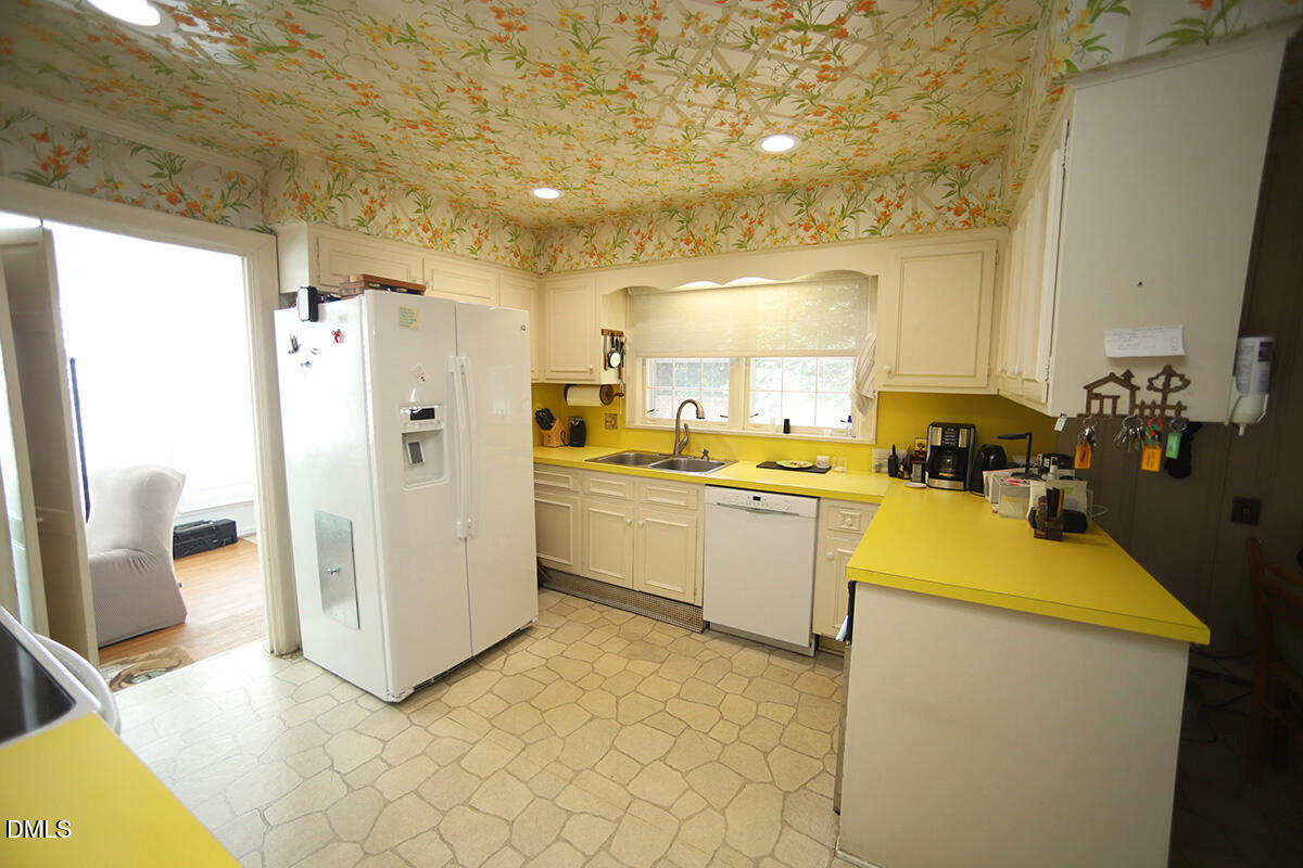 2601 York Road Raleigh, NC 27608 - Photo 6 of 24 a kitchen with a refrigerator sink and white cabinets