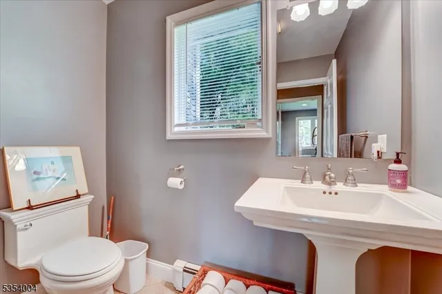 a bathroom with a sink a toilet and mirror
