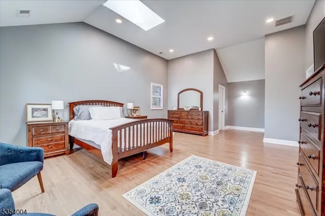 a bedroom with a bed and a dresser with mirror