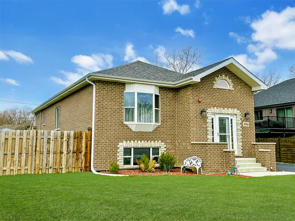 a front view of a house with a garden and yard
