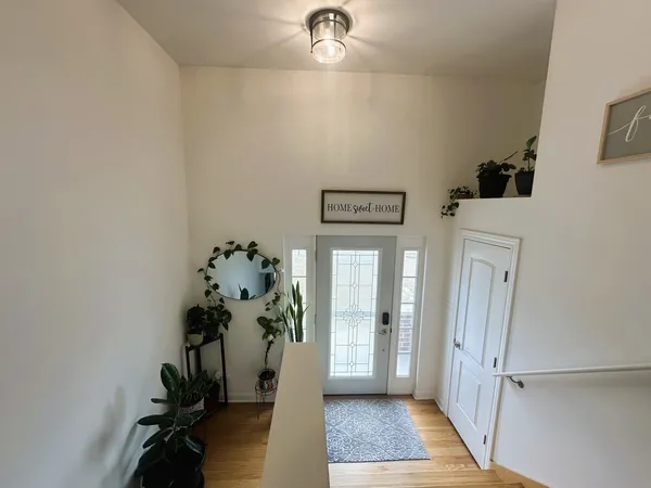 a living room with stainless steel appliances kitchen island a table and a flat screen tv