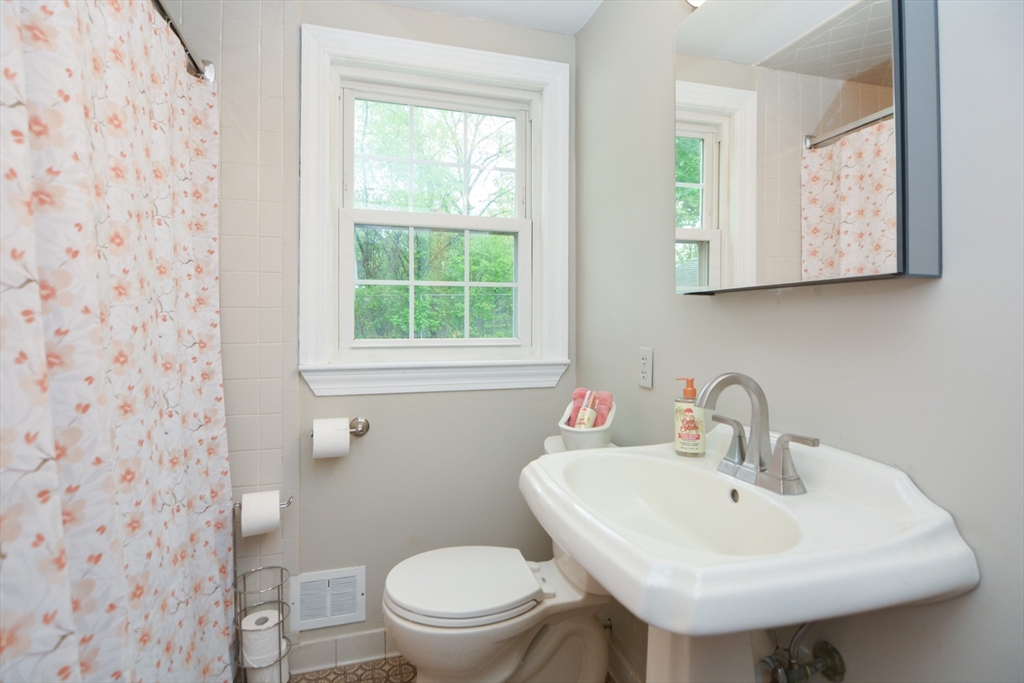 95 Sunset Avenue Dedham, MA 02026 - Photo 17 of 39 a bathroom with a sink a mirror and a toilet