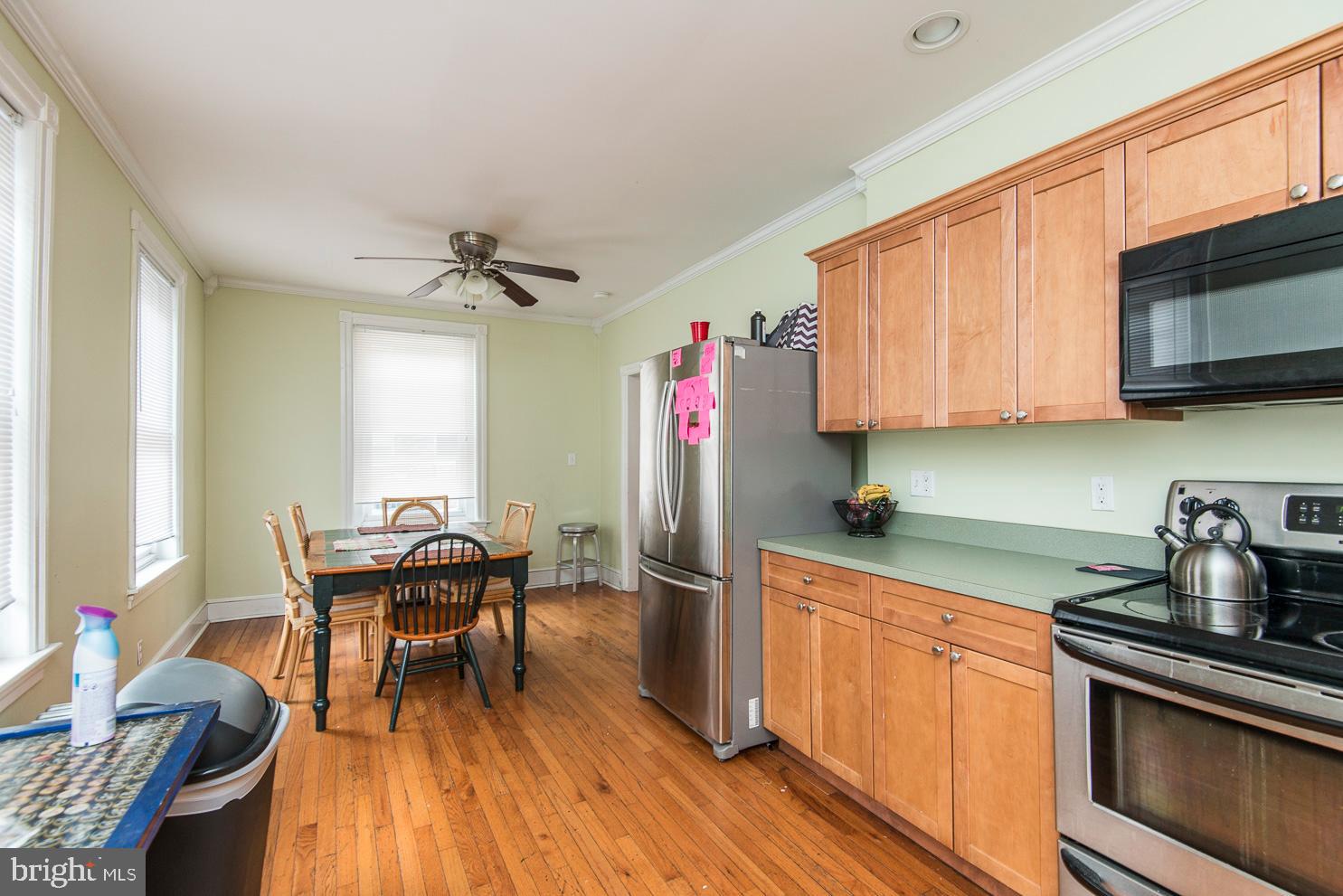 133 Dupont Street Philadelphia, PA 19127 - Photo 5 of 24 a kitchen with stainless steel appliances granite countertop a stove top oven a sink dishwasher a dining table and chairs with wooden floor