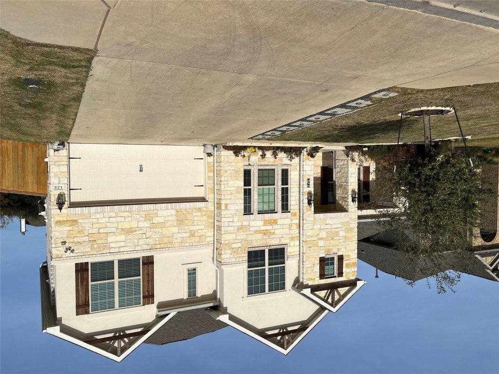 121 Red Granite Road Georgetown, TX 78633 - Photo 1 of 23 Front of home with stone siding, driveway, an attached garage, stucco siding, and a front yard