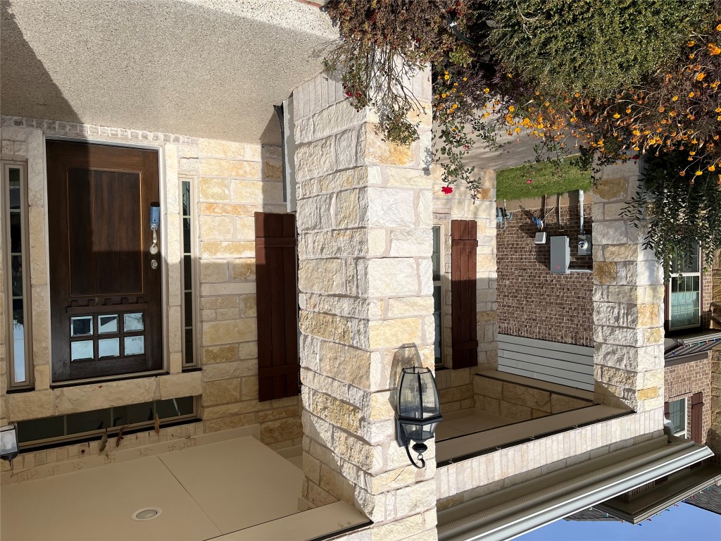 121 Red Granite Road Georgetown, TX 78633 - Photo 2 of 23 Doorway to property featuring stone siding and covered porch, and epoxy porch