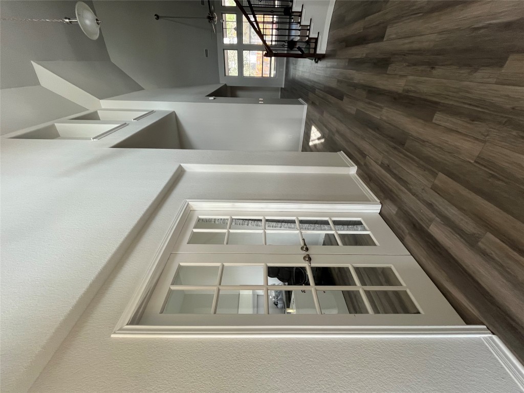 121 Red Granite Road Georgetown, TX 78633 - Photo 3 of 23 Hallway featuring high vaulted ceiling, dark wood-type flooring, french doors, stairs, and a textured wall