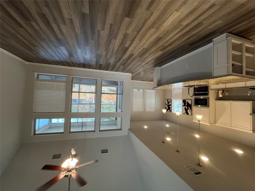 121 Red Granite Road Georgetown, TX 78633 - Photo 7 of 23 Kitchen featuring white cabinets, hanging light fixtures, dark wood-style flooring, ceiling fan, and lofted ceiling