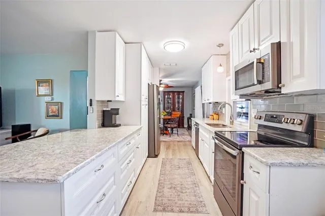 a large kitchen with stainless steel appliances granite countertop a lot of counter space and wooden floor