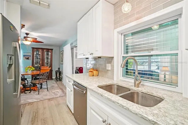 a kitchen that has a sink cabinets and window
