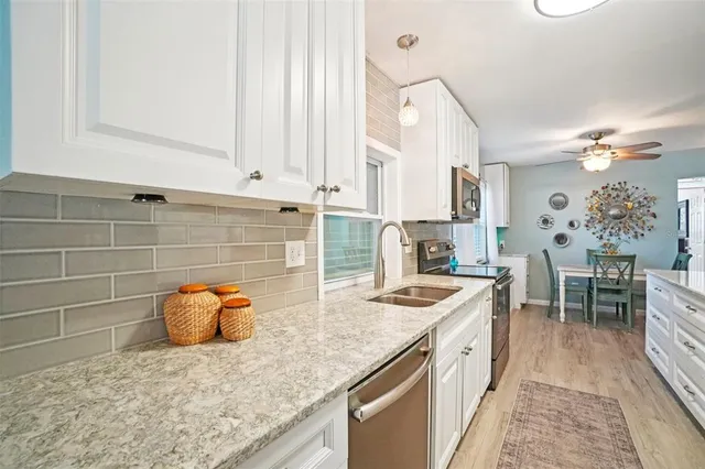 a kitchen with stainless steel appliances granite countertop a sink stove and cabinets