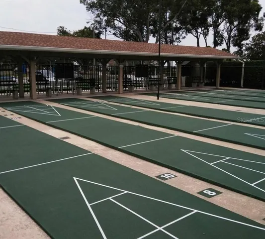 a view of a tennis ground with large trees