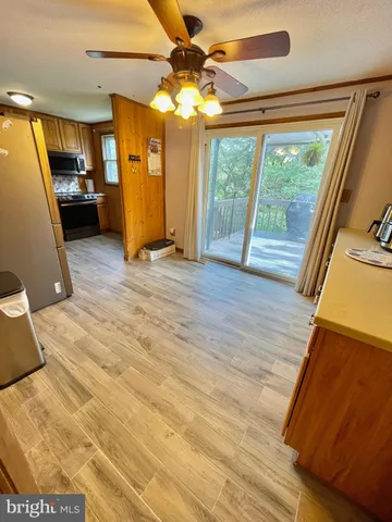 a view of a living room with hardwood floor and a ceiling fan