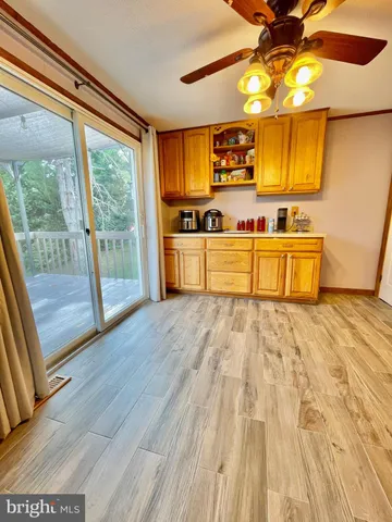 a large kitchen with stainless steel appliances wooden floors and a large window
