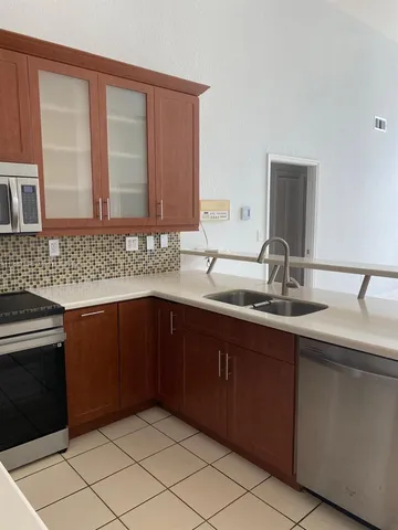 a kitchen with a sink a counter and a mirror