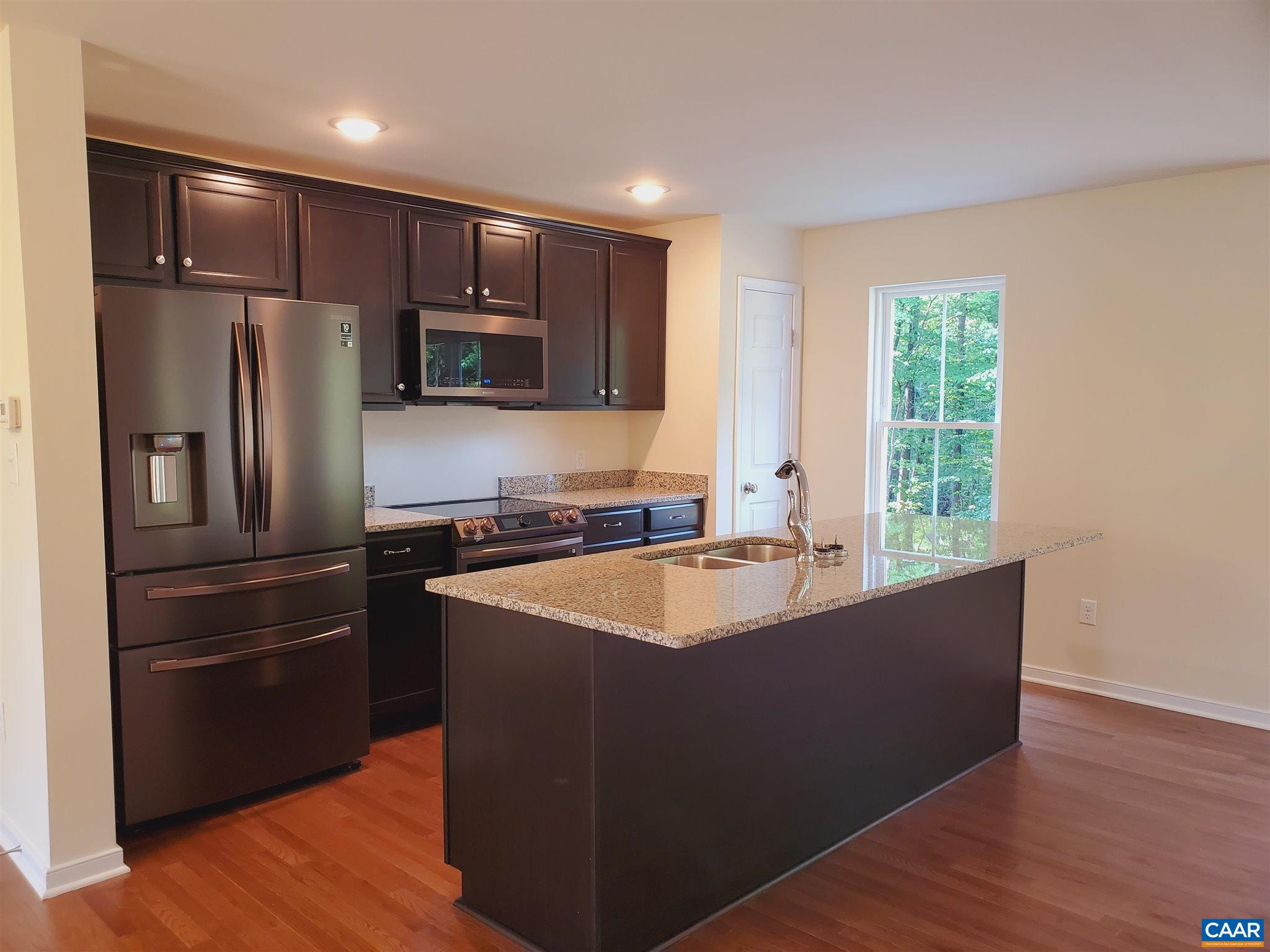 4152 Rising Sun Road Palmyra, VA 22963 - Photo 6 of 24 a kitchen with kitchen island granite countertop a sink and refrigerator