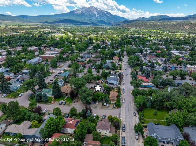 an aerial view of residential houses with outdoor space and trees