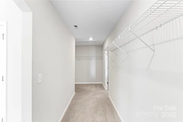 a view of a hallway with toilet and a shower