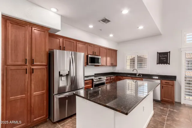 a kitchen with stainless steel appliances granite countertop a refrigerator stove and microwave