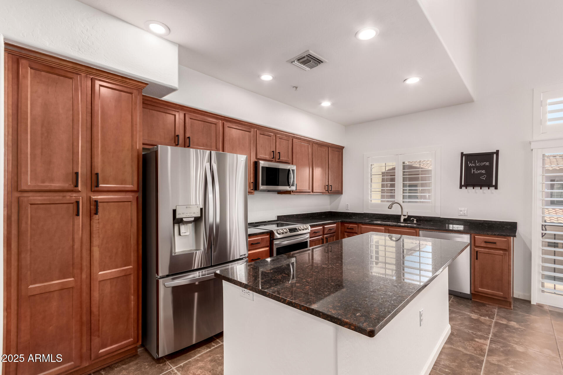 3935 East Rough Rider Road, Unit 1076 Phoenix, AZ 85050 - Photo 12 of 48 a kitchen with stainless steel appliances granite countertop a refrigerator a sink a stove a microwave and island