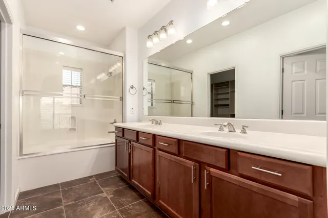 a bathroom with a shower sink vanity and mirror