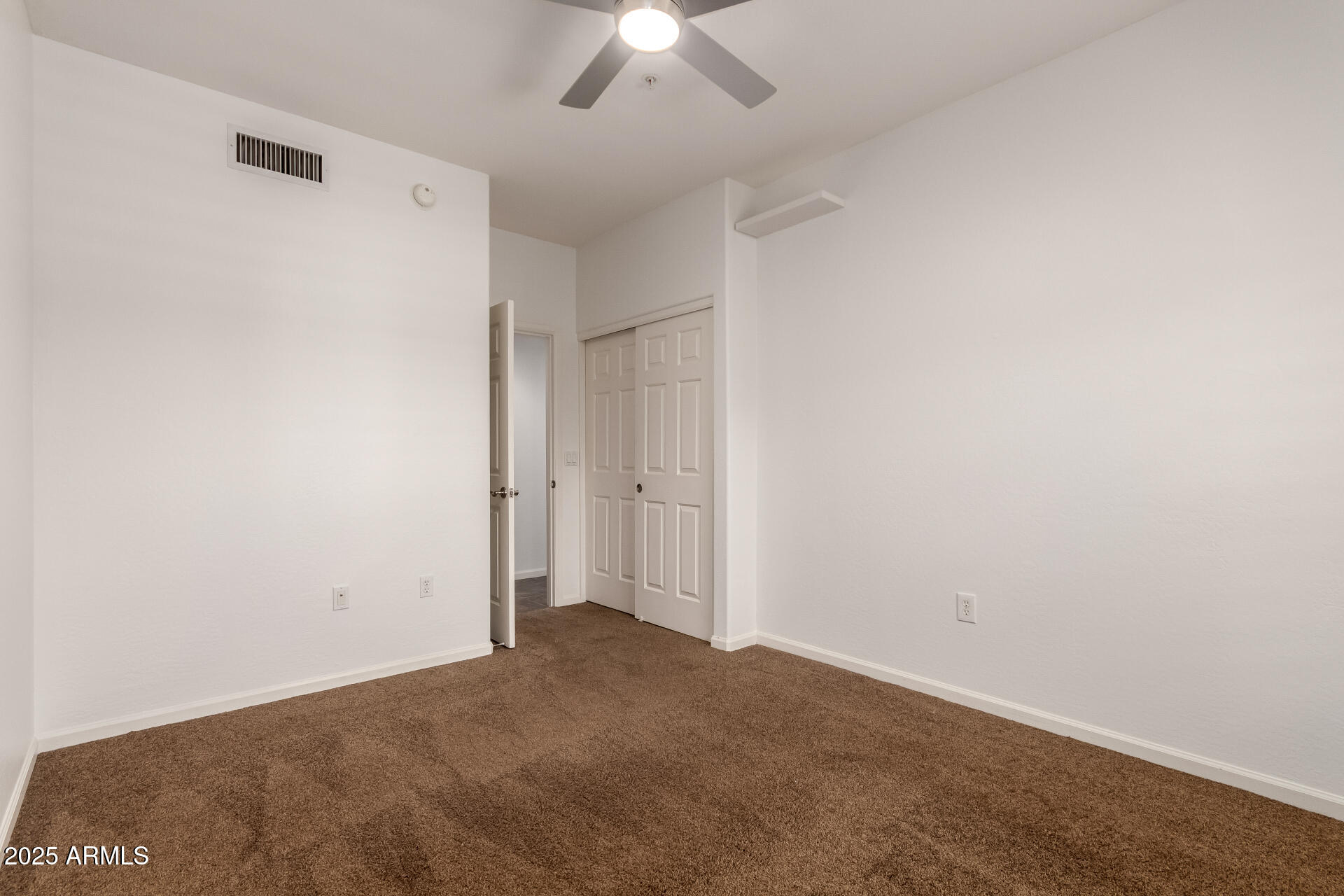3935 East Rough Rider Road, Unit 1076 Phoenix, AZ 85050 - Photo 21 of 48 an empty room with a ceiling fan and a window