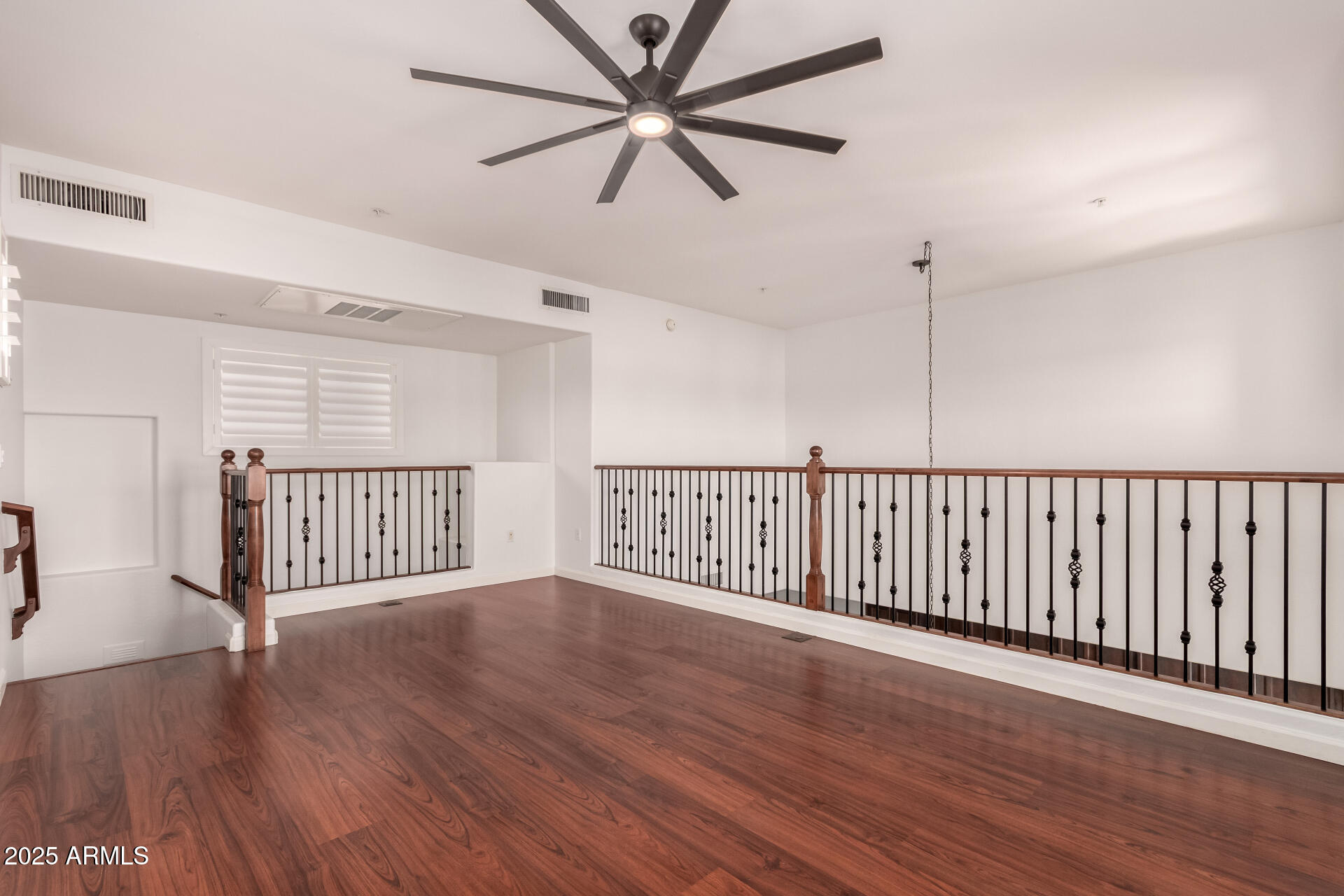 3935 East Rough Rider Road, Unit 1076 Phoenix, AZ 85050 - Photo 25 of 48 a view of an empty room with wooden floor and a window