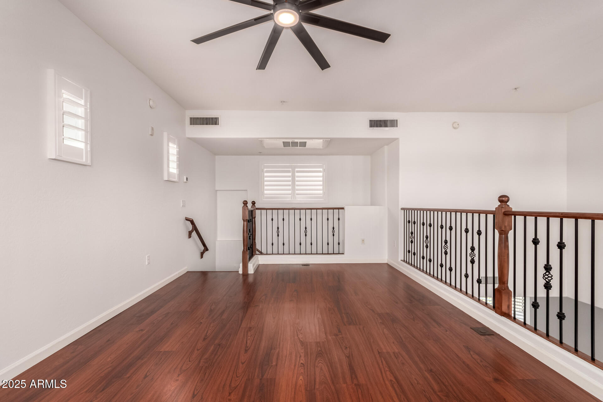 3935 East Rough Rider Road, Unit 1076 Phoenix, AZ 85050 - Photo 26 of 48 a view of an empty room with wooden floor and a window