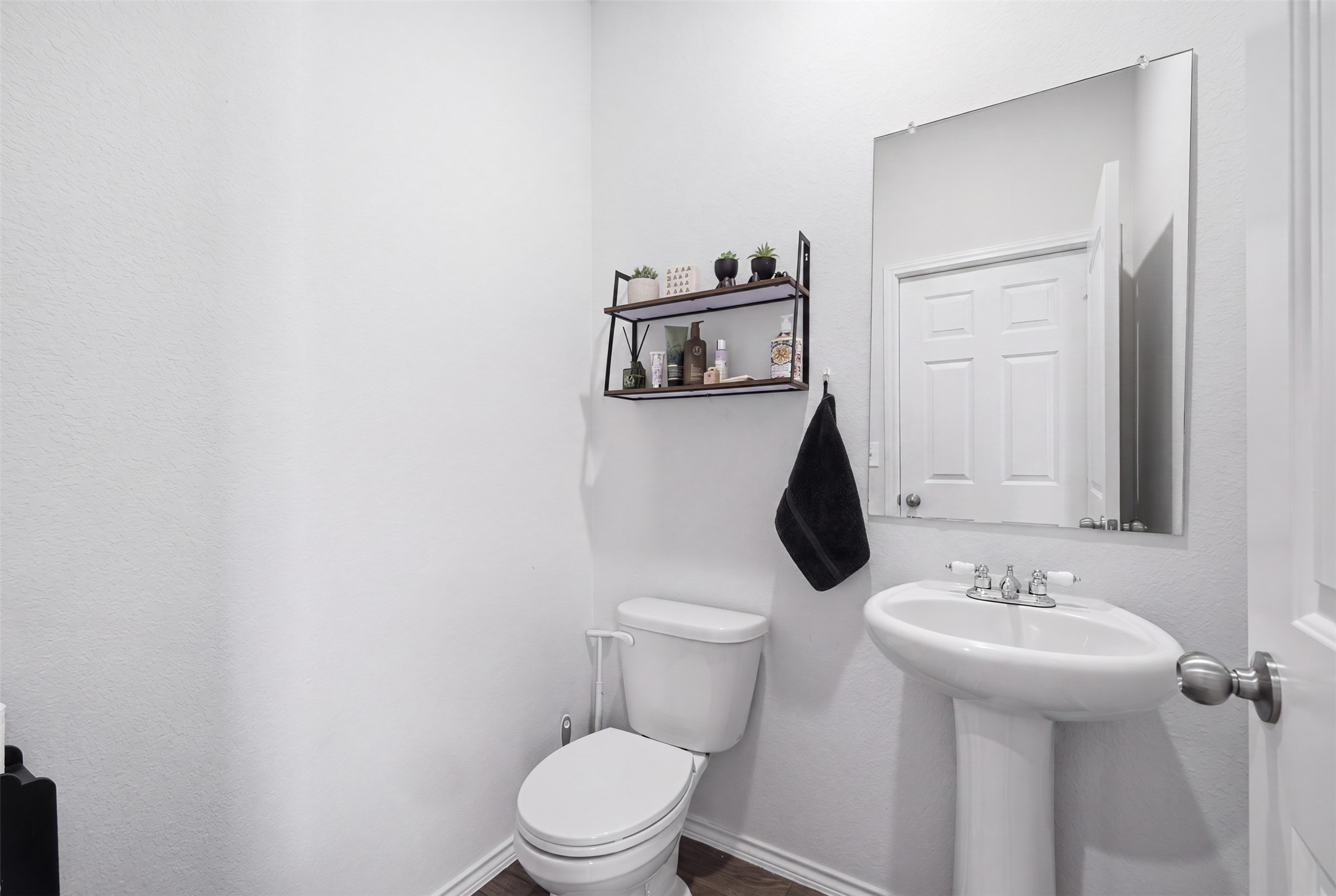 15000 Bajada Rd Manor Manor, TX 78653 - Photo 5 of 31 A well-appointed powder room features a classic pedestal sink and modern shelving.