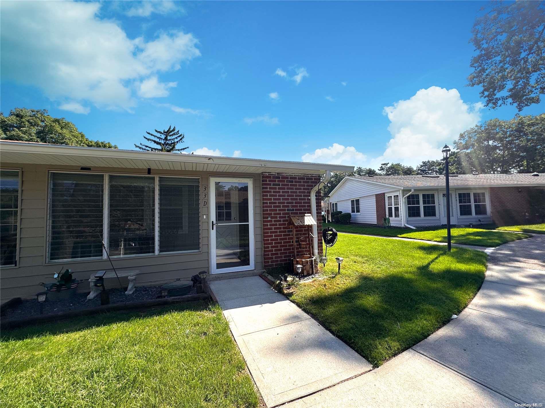 33 Trent Court, Unit D Ridge, NY 11961 - Photo 1 of 1 a front view of a house with a yard table and chairs