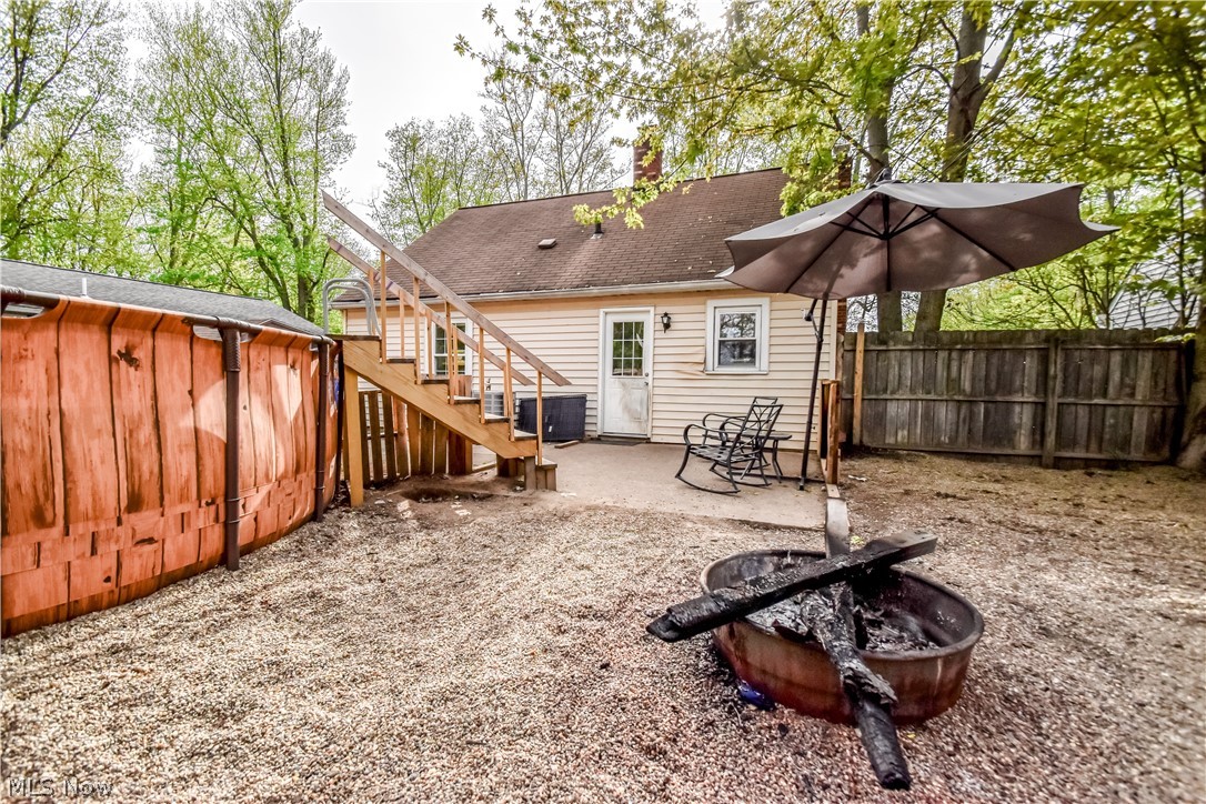 1969 Paisley Road Madison, OH 44057 - Photo 20 of 20 Rear exterior featuring a concrete patio, wood deck stairs, and a gravel yard