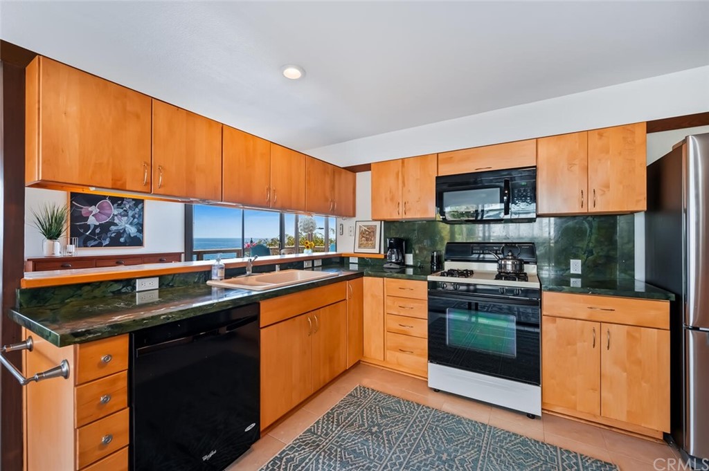 1944 Ocean Way Laguna Beach, CA 92651 - Photo 8 of 25 a kitchen with stainless steel appliances granite countertop a stove a sink dishwasher and a microwave oven with cabinets