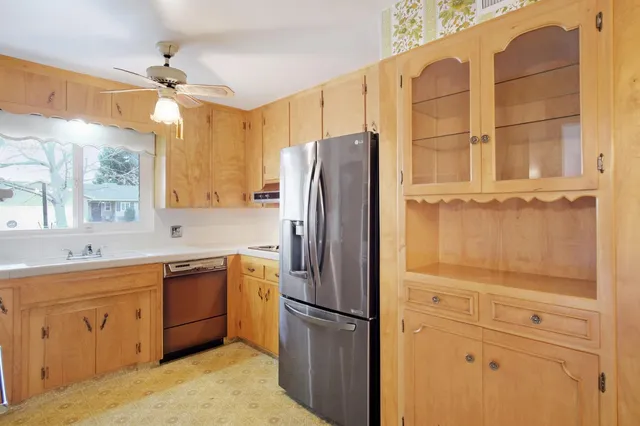 a kitchen with a refrigerator a sink and cabinets