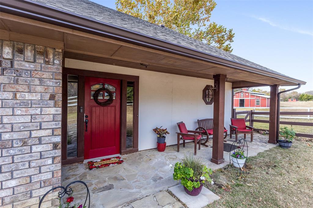 1495 Snider Lane Lucas, TX 75002 - Photo 21 of 39 View of exterior entry featuring a porch, stone siding, and a shingled roof