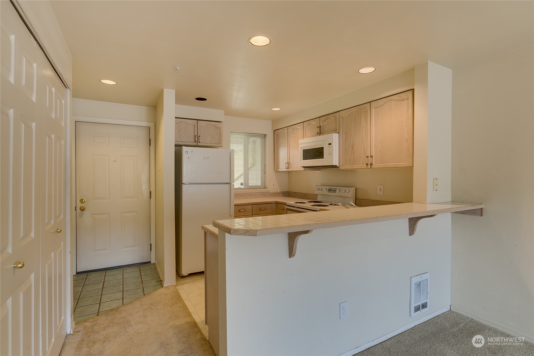 15711 Waynita Way Northeast, Unit H203 Bothell, WA 98011 - Photo 8 of 22 a kitchen with stainless steel appliances granite countertop a refrigerator a sink dishwasher a stove and white countertops with wooden floor