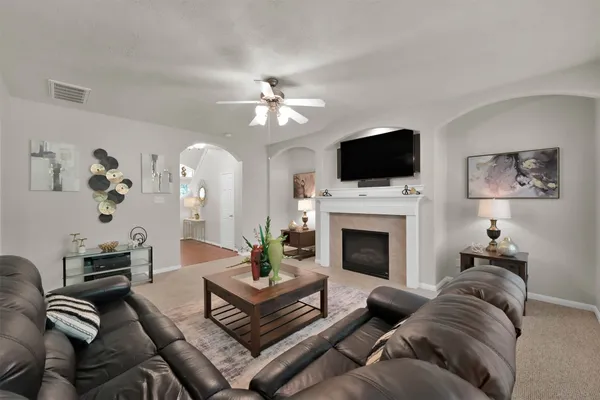 a living room with furniture a flat screen tv and a fireplace