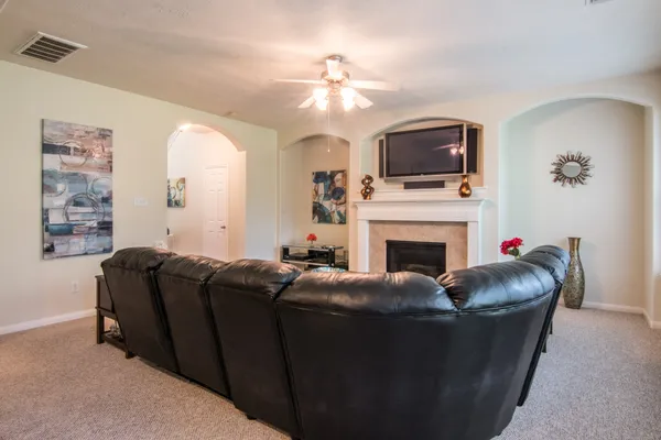 a living room with furniture a flat screen tv and a fireplace