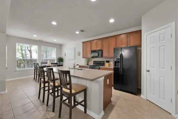 a kitchen with a dining table chairs refrigerator and cabinets