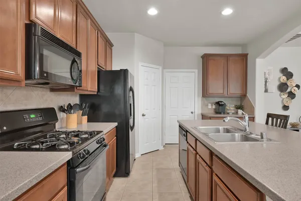a kitchen with stainless steel appliances granite countertop a sink stove and refrigerator
